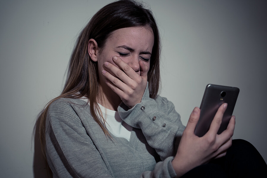upset girl looking at mobile phone