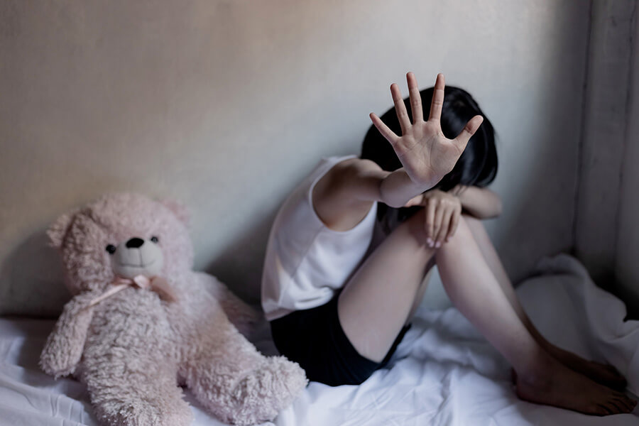 young boy hiding his face with his hand up indicating stop
